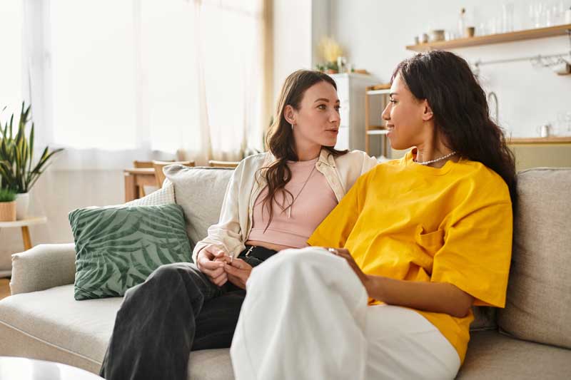 soothing care from a friend, two women sitting on couch talking