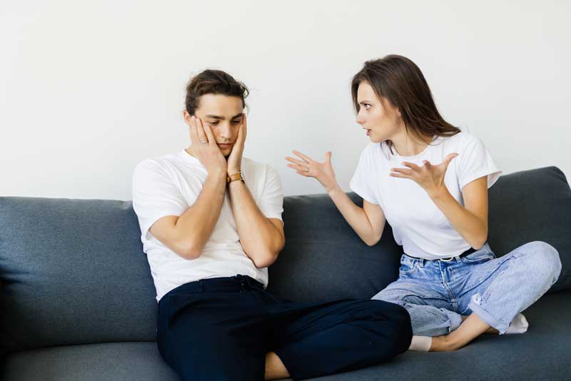 Woman yelling at man on couch